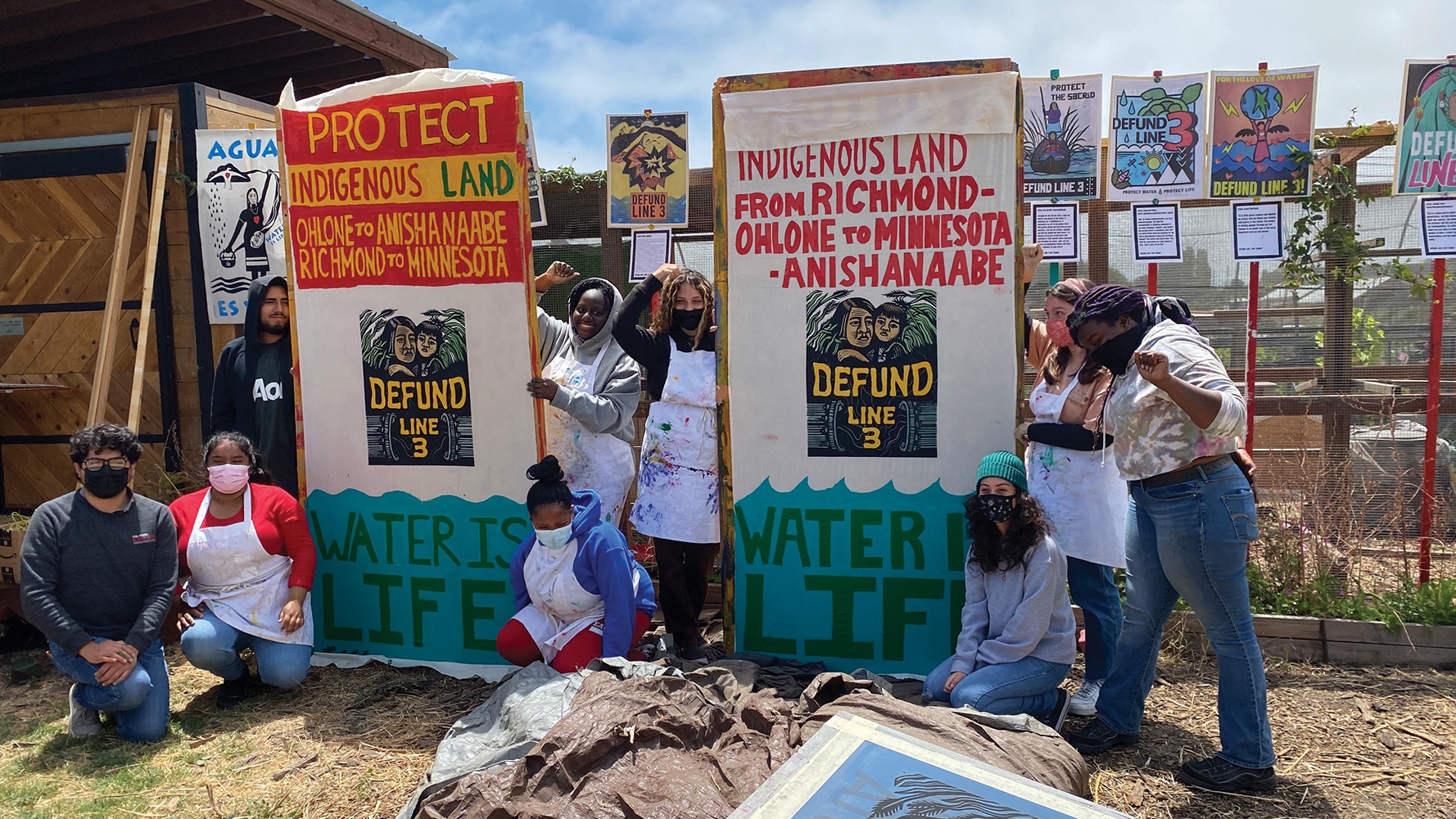 Urban Tilth Apprentices in Richmond, CA – Paint solidarity banners and Host a Defund Line 3 Post Art Pop-Up Art Show (on the chicken coop) after learning about Line 3, Treaty Rights and Wild Rice Harvesting.