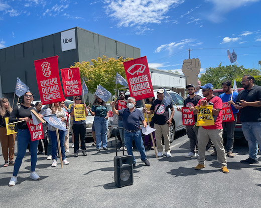 Drivers stand in front of Uber headquarters and demand fair pay